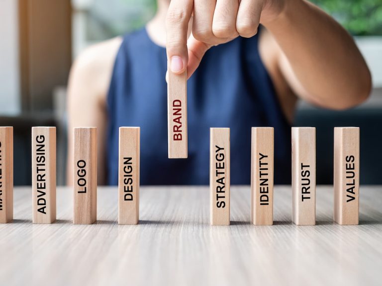 businesswoman-hand-placing-wooden-dominoes-with-te-2021-09-01-12-17-43-utc (1)